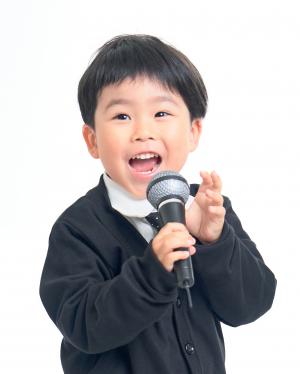 小道具のマイクを手にした少年
